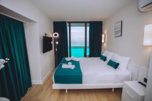 巴统Come a Lot Aparthotel Batumi的一间卧室配有一张带绿色窗帘的大床