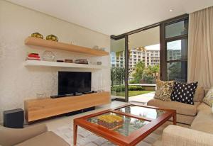 开普敦Luxury Villa in V&A Waterfront的客厅配有电视、沙发和桌子