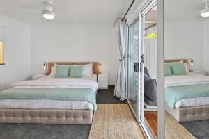 库鲁姆海滩Private Outdoor Spa, Fire Pit - THE RETREAT COOLUM BEACH的一间卧室配有两张床和镜子