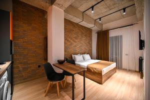 埃里温Rooms Apart-Hotel by RED的卧室配有一张床和一张木桌及椅子