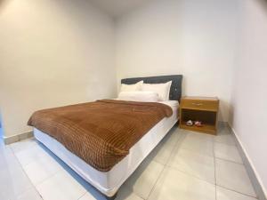 SaroakoVilla Matano Sorowako 2 Redpartner的一间卧室配有一张带棕色毯子和床头柜的床
