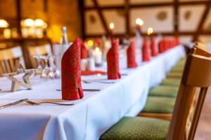 本特维施赫尔曼兰德加特酒店的一张长桌,上面有红色的餐巾