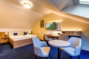 本特维施赫尔曼兰德加特酒店的卧室配有一张床和一张桌子及椅子