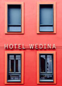 汉堡阿尔斯特维迪纳酒店的一座红色的建筑,有三个窗户,酒店是一座