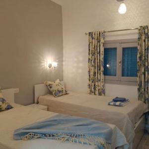 卢克索desert pearl beautiful cosy new home的一间卧室设有两张床和窗户。