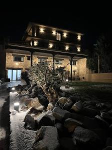 杜鲁埃洛德拉谢拉Duruelo Mountain Suites的一座在岩石花园前的建筑,在晚上