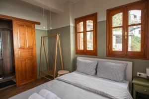 马克里尼撒The Fern House的一间卧室配有一张带白色床单和窗户的床。