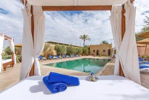 马拉喀什Maison Daouia的游泳池景客房的一张床位