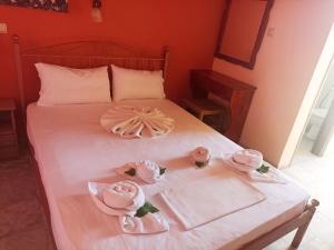 拉加纳斯尤金妮亚酒店及公寓 的一张带粉红色毛巾和粉红色玫瑰的床