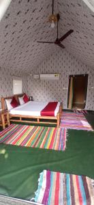 兰纳加Corbett Nature Retreat的一间卧室配有床和色彩缤纷的地毯
