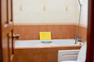 大城Onvara Place的浴室设有浴缸,上面有黄色标志