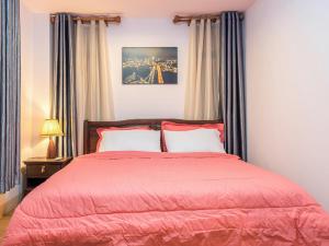 大城Onvara Place的一间卧室配有一张红色棉被的床