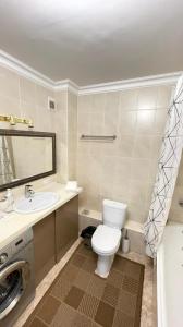 阿斯塔纳На Тархана的浴室配有卫生间、盥洗盆和洗衣机。