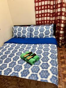 宿务梅的客乡之家公寓的一张带蓝色和白色棉被和枕头的床