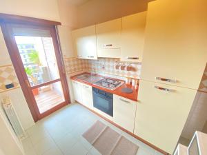 菲乌米奇诺Casa Relax con Terrazza Panoramica的一间小厨房,配有白色的橱柜和窗户