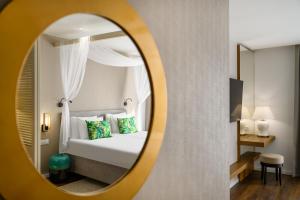 桑托德Mövenpick Balaland Resort Lake Balaton的酒店客房,配有床和镜子