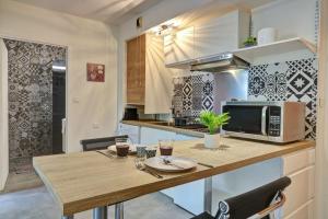 圣丹尼斯Le Zévi - appt T2 Saint Denis的厨房配有木桌和微波炉