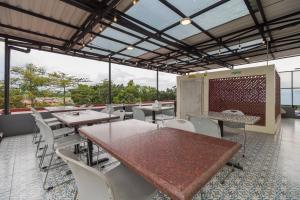 雅加达Urbanview Hotel Cantee Halim Perdanakusuma by RedDoorz的餐厅设有桌子和白色的椅子以及窗户。