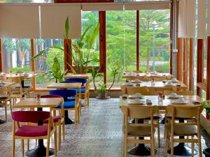NakasongNakasang Paradise Hotel的用餐室设有桌椅和窗户。
