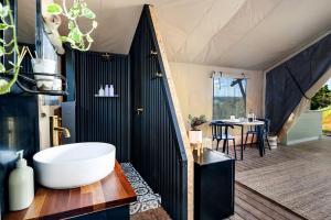 凯阿玛Cicada Luxury Camping的一间带白色浴缸和桌子的浴室