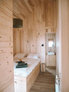 Saint-Amand-de-ColyDomaine St-Amand的卧室配有木墙内的一张床