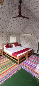 兰纳加Corbett Nature Retreat的一间卧室配有一张带红色枕头的木床。