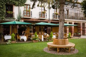 仕格莱伊卡伦美食酒店的一个带树、桌子和遮阳伞的庭院