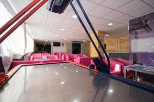 帕斯底拉卡萨Apartaments Turistics Natural Suites Manzano 3000的一间设有粉红色椅子和桌子的等候室