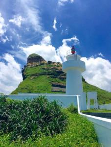 Ruifang晶晶輕旅民宿的山前带椅子的白色灯塔