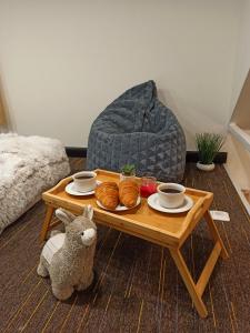纳尔瓦约埃苏Tiny House的咖啡桌,包括羊角面包、杯子和填充动物