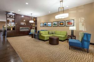 亨特斯维尔Comfort Suites Lake Norman - Huntersville的客厅配有绿色沙发和蓝色椅子
