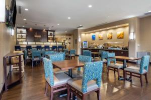 亨特斯维尔Comfort Suites Lake Norman - Huntersville的一间带桌椅的餐厅和一间酒吧