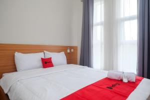 马格朗RedDoorz Syariah near Universitas Tidar Magelang的卧室配有一张带红色毯子的白色床