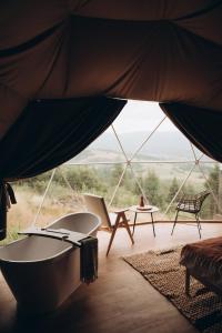 RichkaMandra Hills的客房享有带桌椅的帐篷景致。