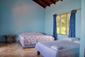 奥霍查尔El Paraiso Azul的蓝色的客房设有两张床和窗户。
