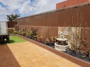 罗萨里奥港Apartamento rural zona céntrica isla的花园设有长凳和围墙旁的桌子