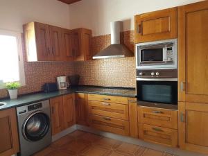 罗萨里奥港Apartamento rural zona céntrica isla的厨房配有木制橱柜、洗衣机和微波炉