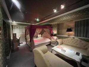 札幌Hotel Pharaoh-Adult Only的一间卧室配有一张床和一个沙发