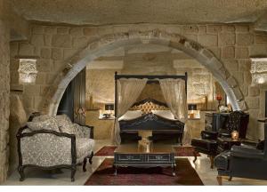 于尔居普Seraphim Cave Suites & SPA的一间带床和石墙的客厅