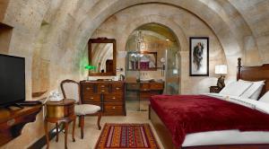于尔居普Seraphim Cave Suites & SPA的一间卧室配有一张床,浴室设有水槽
