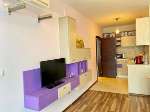 普里莫尔斯科Green Paradise Deluxe Apartments的客厅配有壁挂式紫色电视