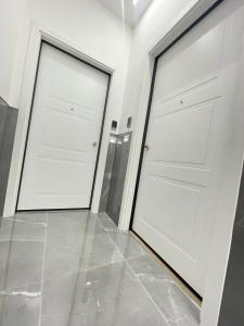 福贾B&B MANFREDI的铺有瓷砖地板的客房内设有两扇白色门