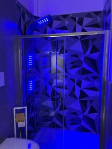 福贾B&B MANFREDI的浴室设有蓝色灯光玻璃淋浴间