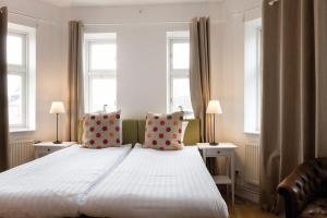 隆德隆德阿姆斯主教酒店的卧室配有一张白色大床和两个窗户