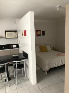 圣若泽Apartamento Studio com banheiro privativo的一间卧室配有一张床、一张桌子和一张桌子