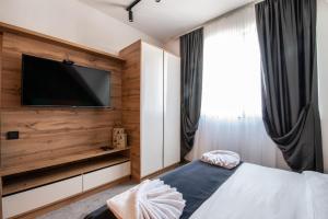 科帕奥尼克Hotel Djina - Kopaonik的一间卧室设有平面电视和一张床。