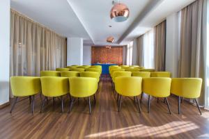 拉纳卡Lordos Beach Hotel & Spa的一间设有黄色椅子和桌子的会议室