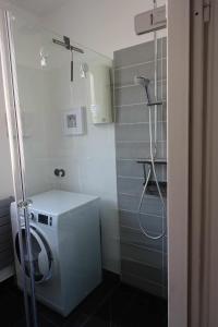 柏林Ferienunterkunft im Tegelhaus的一间带洗衣机和淋浴的浴室