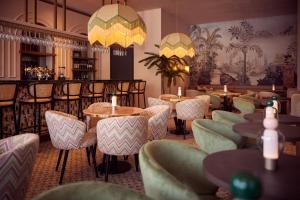 莱利斯塔德Van der Valk Hotel Lelystad的一间带桌椅的餐厅和一间酒吧