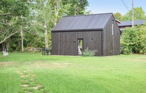 LyckebyGuest house on Fäjö的绿草丛中的黑色谷仓